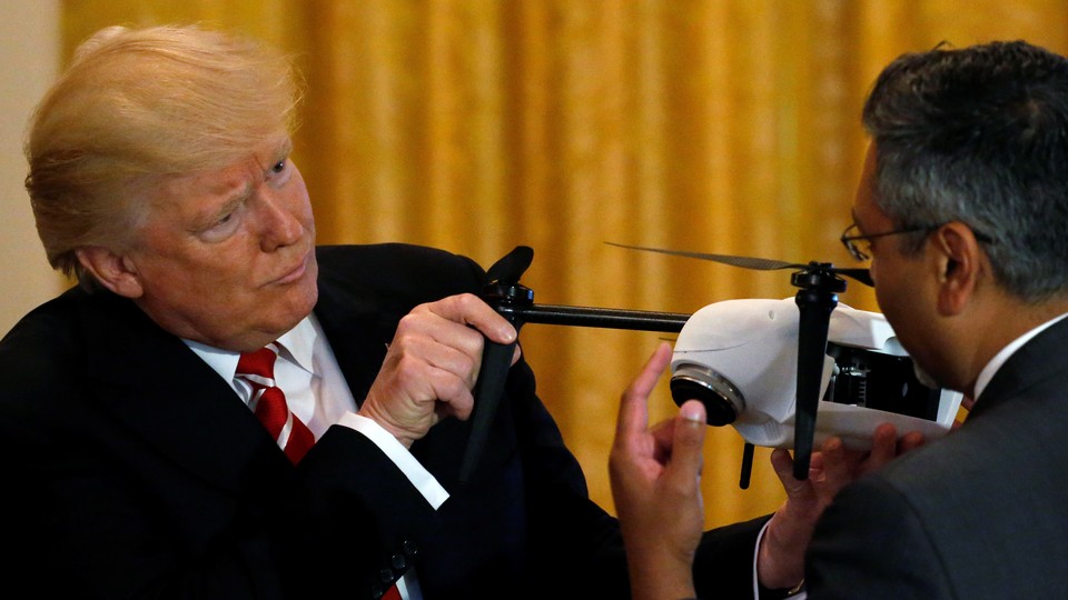 Trump holds the propellers of a small drone.