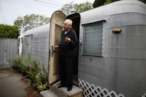 A man standing in the doorway of his mobile home