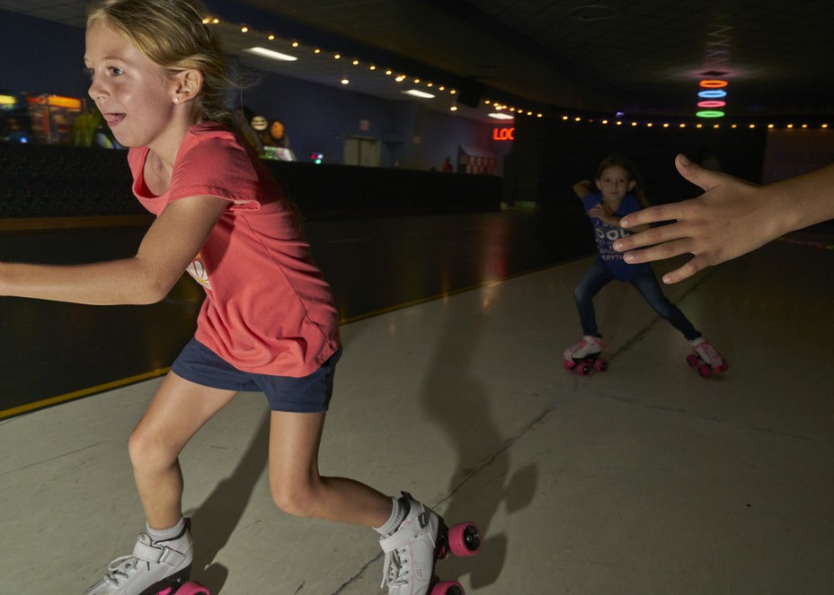 a girl skates by a hand out