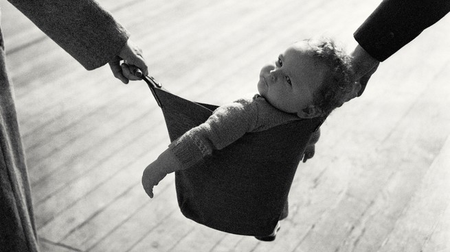 A baby being held by two different hands