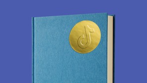 A book with a golden sticker showing TikTok's logo on the front