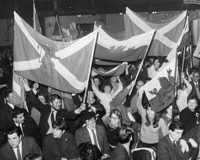 Members of the Scottish National Party and Plaid Cymru, the Welsh National Party, cheer during a joint conference at Caxton Hall in London. They are celebrating Scottish Nationalist Winifred Ewing MP taking her seat at the House of Commons.