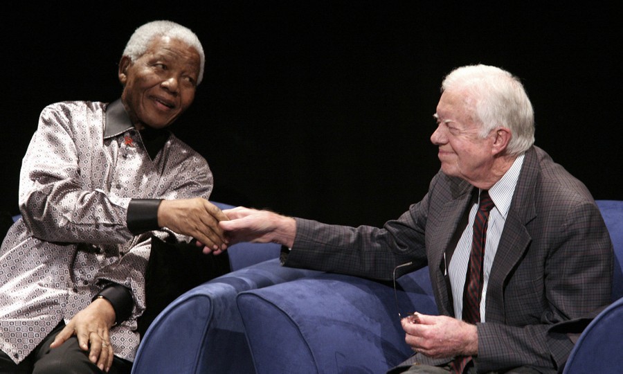 Nelson Mandela shakes hands with Jimmy Carter.
