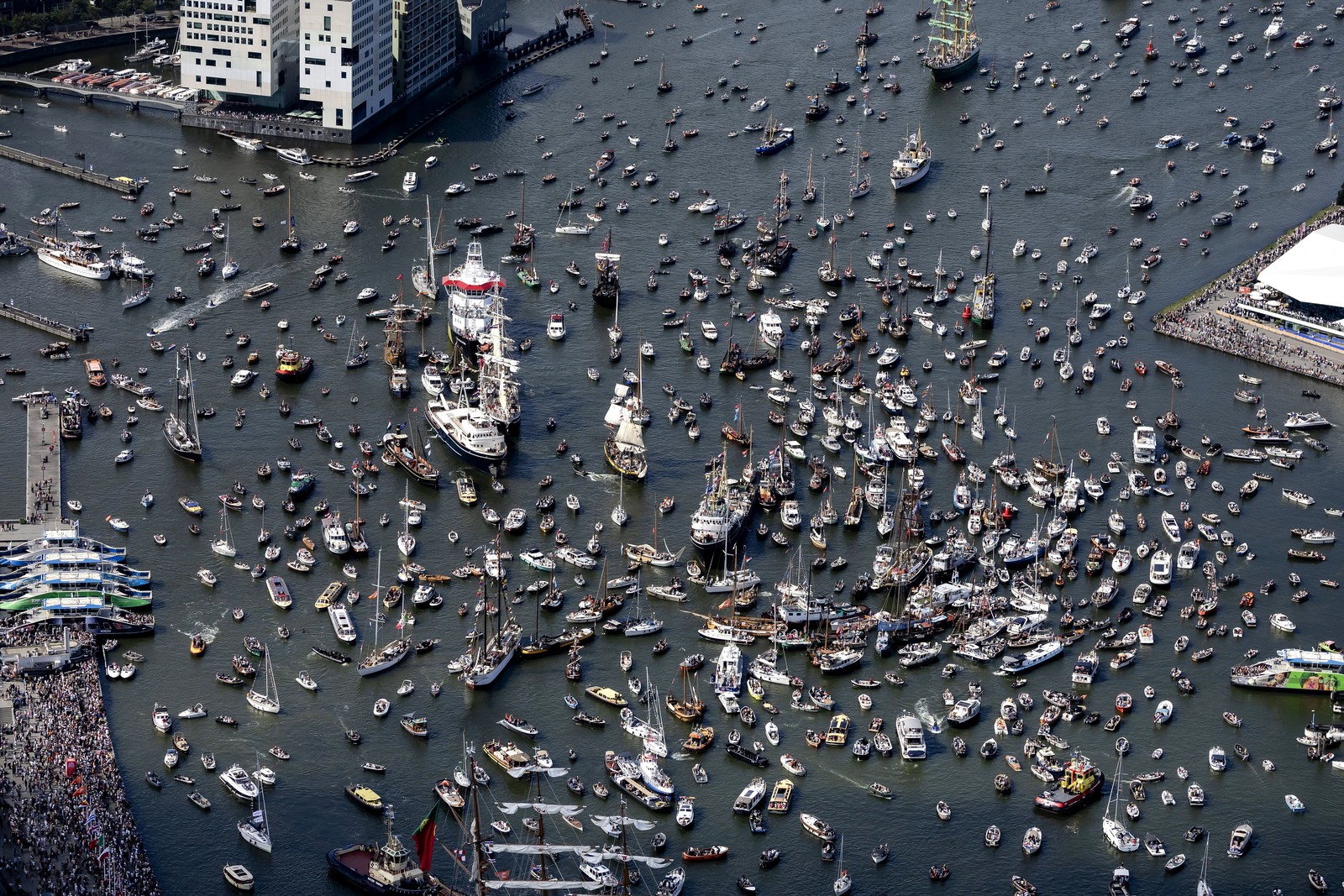 An aerial view of many boats and ships of all sizes crowded into a harbor.