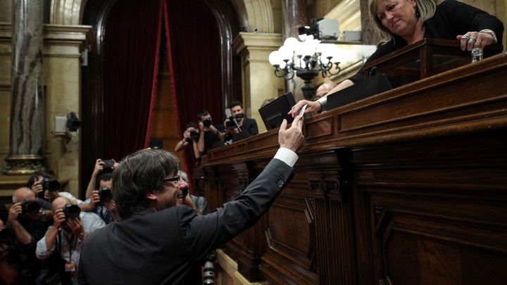 Catalan President Carles Puigdemont hands in his ballot during a vote on independence from Spain at the Catalan regional Parliament in Barcelona, Spain on October 27, 2017.