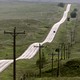 A road surrounded by green hills on the Pine Ridge Indian Reservation, in South Dakota