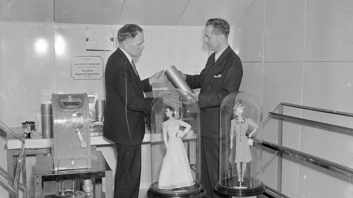 Two men in suits look at a steel tube inside Oglethorpe University's Crypt of Civilization.