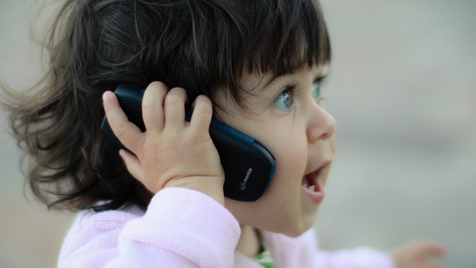 a small girl talking on a phone