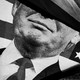 Black-and-white close-up of a billowing American flag featuring a picture of Donald Trump