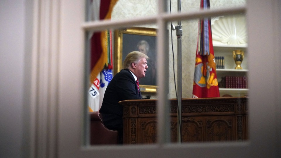 Trump in the Oval Office, seen through a window