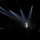 Suga sings in a dark arena, with five spotlights on him.