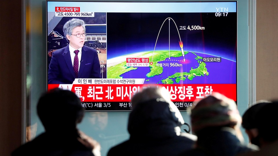 People watch a television broadcast of a news report on North Korea firing what appeared to be an intercontinental ballistic missile.