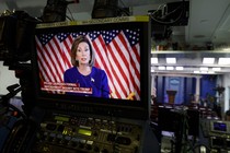 Nancy Pelosi appears on a video screen at the back of the White House press briefing room.