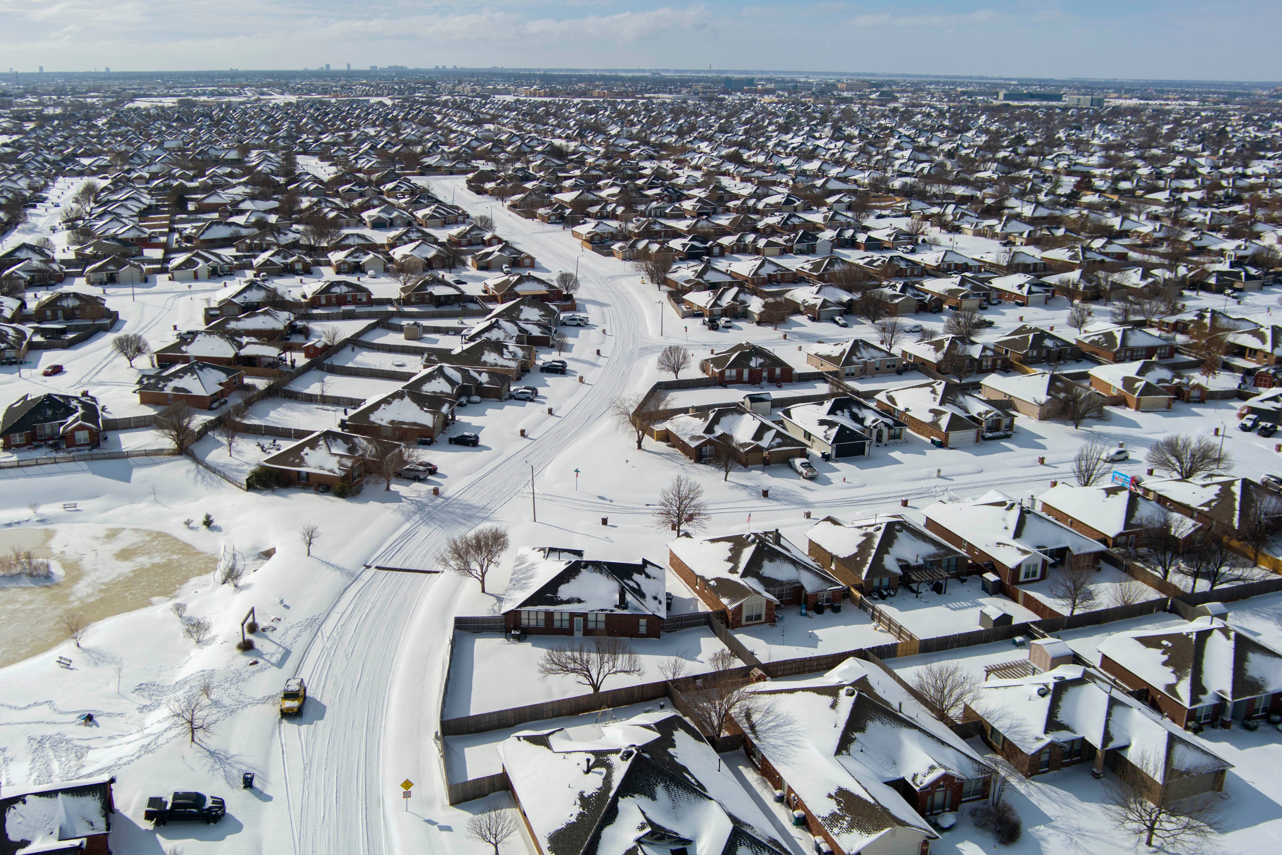 An aerial view of a residential neighborhood covered in a fresh snowfall.