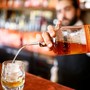 A bartender pours a glass of bourbon whiskey