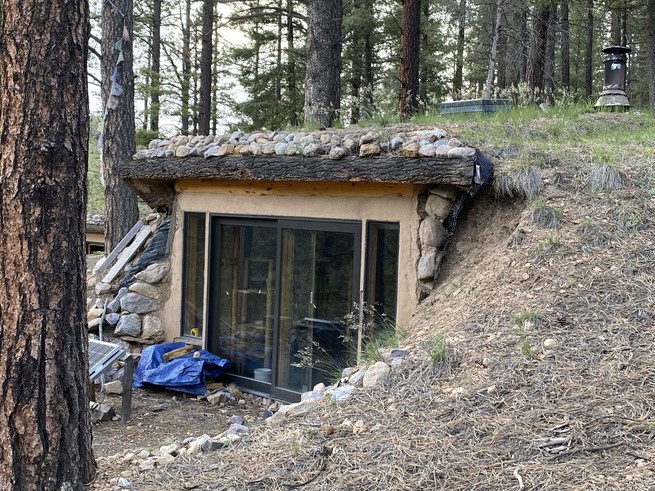 The partially underground meditation cave, with windows looking out into the forest 