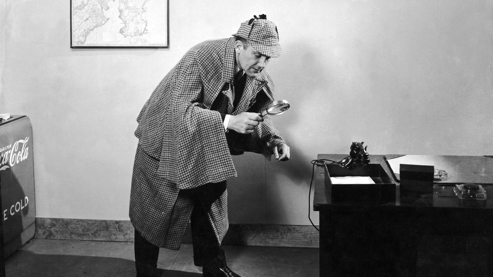 A detective looks through a magnifying glass.