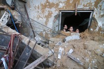 Palestinian children look at the building of the Zanon family, destroyed in Israeli airstrikes in Rafah, Gaza Strip, Saturday, Oct. 14, 2023.