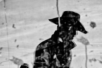 A black-and-white photo of the silhouette of a man with a cowboy hat on