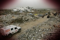 A Reuters truck drives through a bombed refugee camp in Gaza.