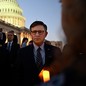 A photo of House Speaker Mike Johnson attending a candlelight vigil outside the U.S. Capitol.