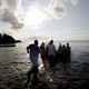 A group of men wade into the ocean as part of a Juneteenth ceremony
