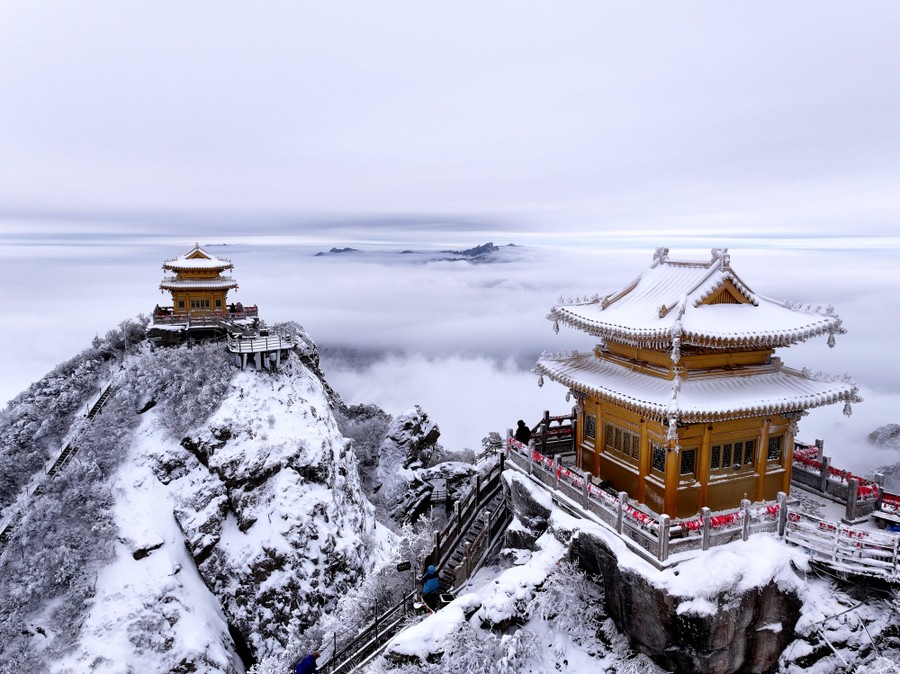 Two pagodas stand on two adjoining steep mountaintops after a recent snowfall.