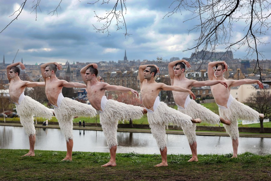 Six dancers wearing feathery costume leggings pose in a park.