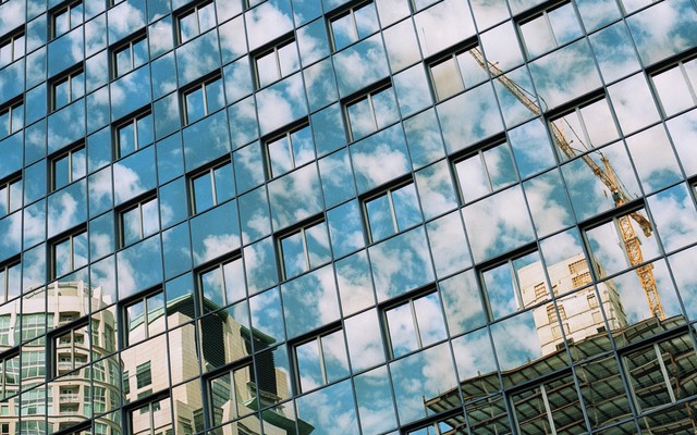 A reflection of a crane constructing new buildings