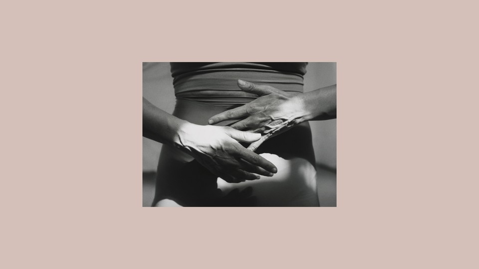 Photograph of a woman's midsection, with her hands awkwardly crossing in front of her body.