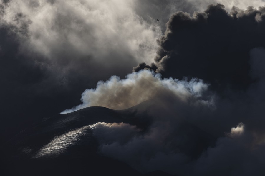 Steam and ash rise from the summit of a volcano.