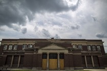 An abandoned, boarded up building in Chicago that two years before this photo was taken housed a school that was later closed