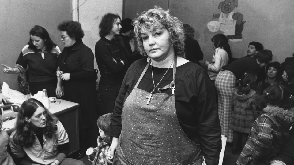 Activist Erin Pizzey stands in a room crowded with other women.