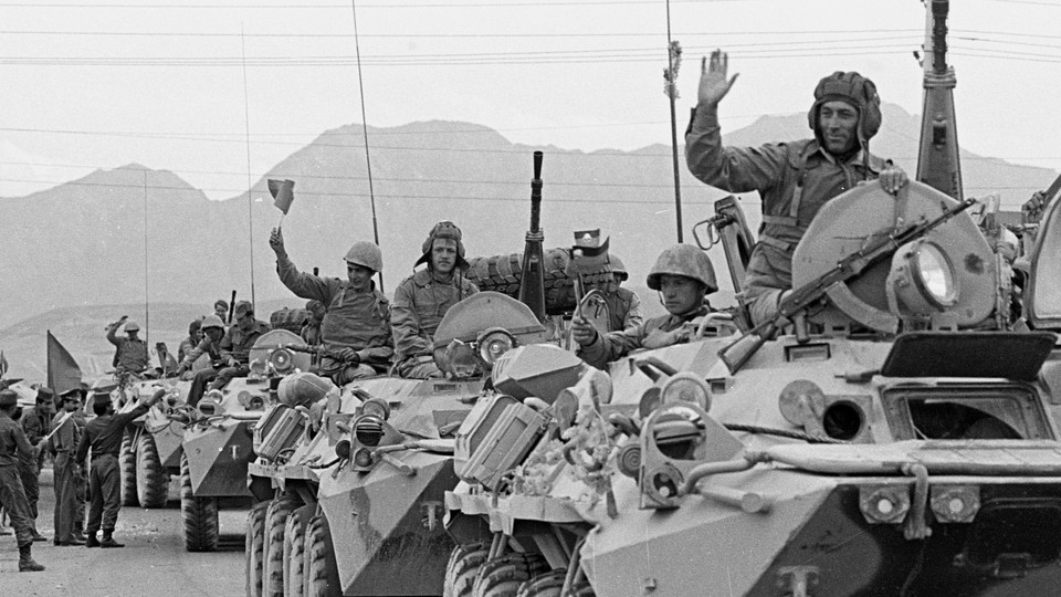 A convoy of Soviet troops waves to crowds during its withdrawal from Afghanistan on May 15, 1988.