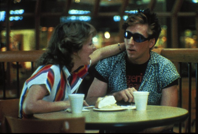 Two characters from'Valley Girl' sit at a dining table