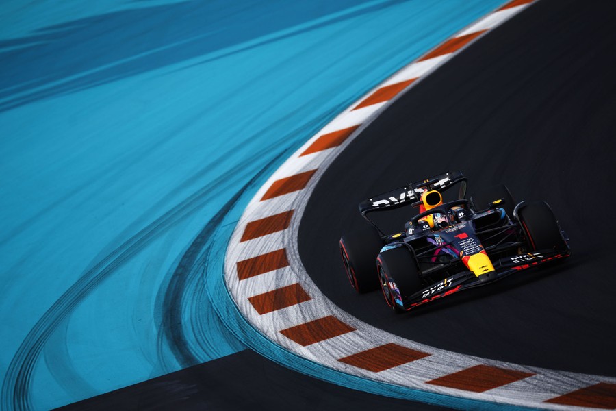 An F1 driver steers through a curve on a track.