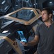 Chris Pratt stands in front of a hibernation pod in the movie Passengers.