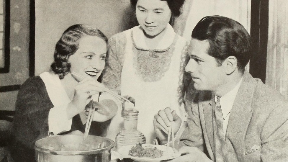 A man and woman eat dinner with their maid