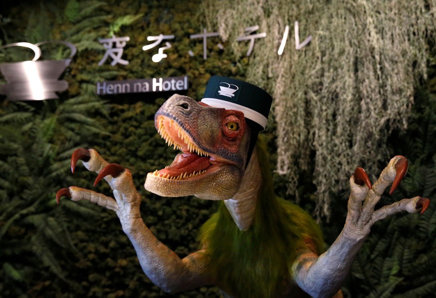 A dinosaur robot acting as a receptionist demonstrates how to check in to the hotel during a press preview for the newly-opening Henn na Hotel Maihama Tokyo Bay in Urayasu, east of Tokyo, Japan, on March 15, 2017. 