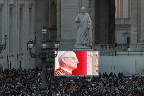 A photo of a crowd watching a screen as the newly elected Pope Leo XIV appears on the balcony of St. Peter's Basilica, at the Vatican