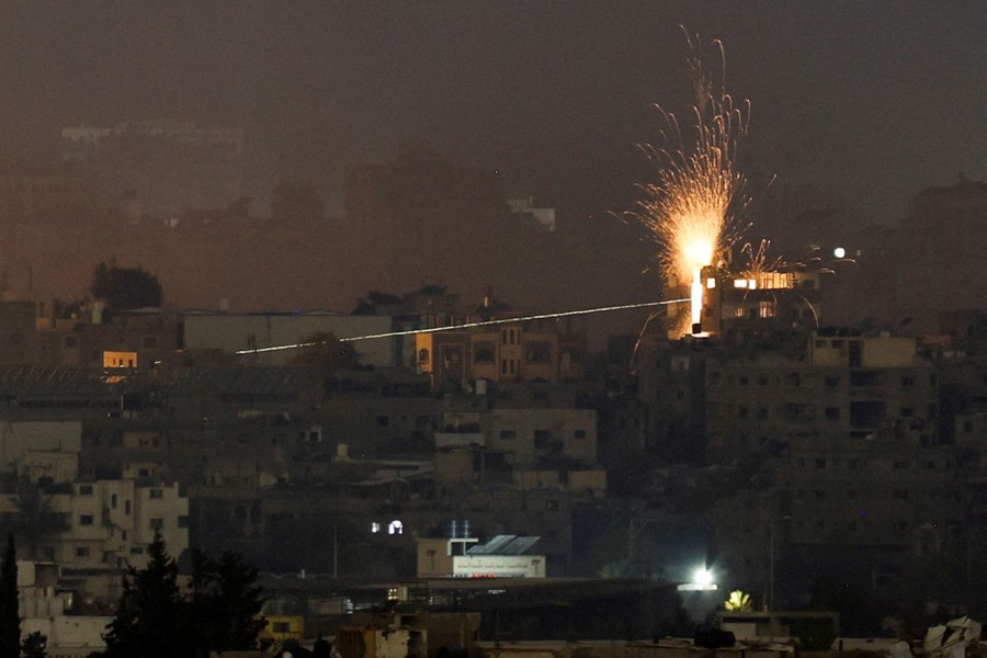 Sparks fly in the air as a missile strikes a building in Gaza.