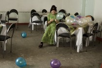 a woman sits at a table with balloons