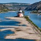 A small historic toll castle sits in the middle of a river, which is at very low level during a drought.
