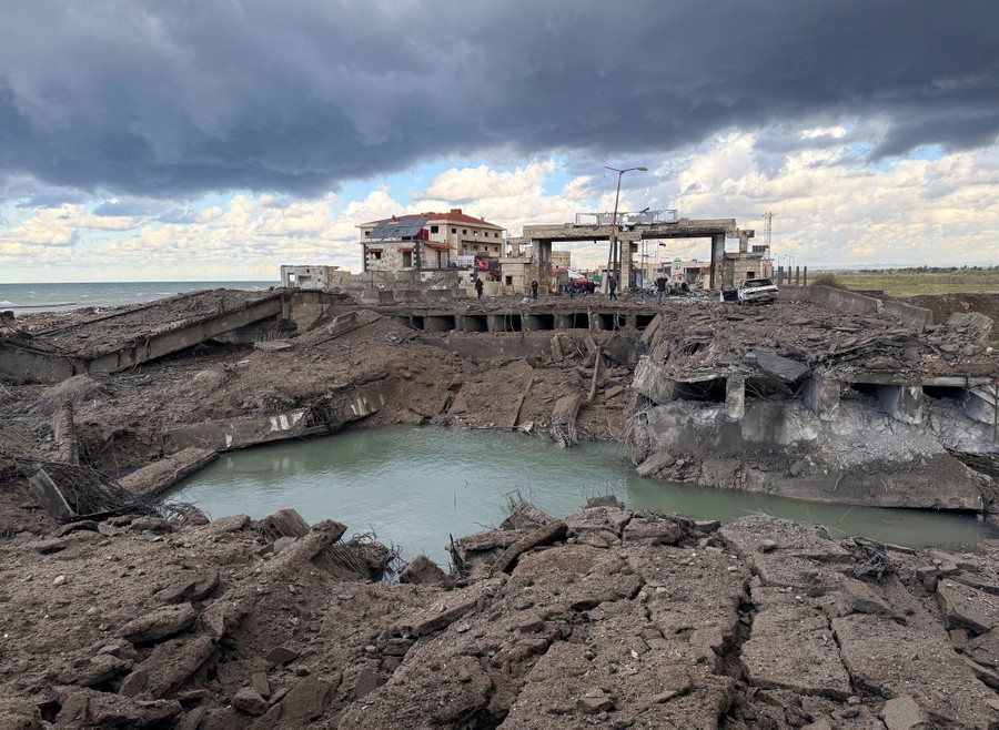 Bomb-damaged structures and a water-filled crater
