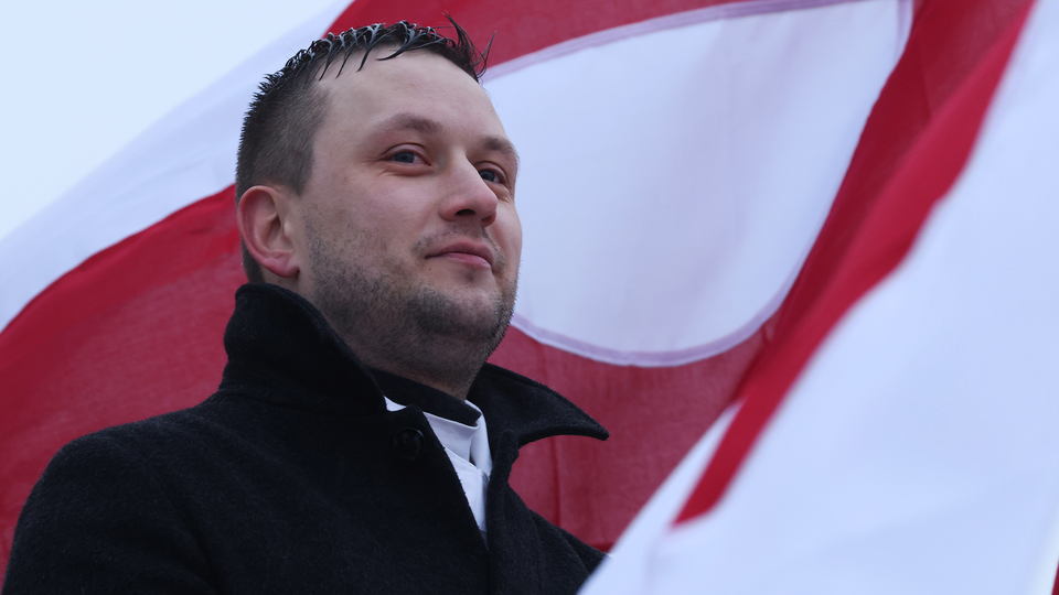 Prime Minister of Greenland in front of a flag