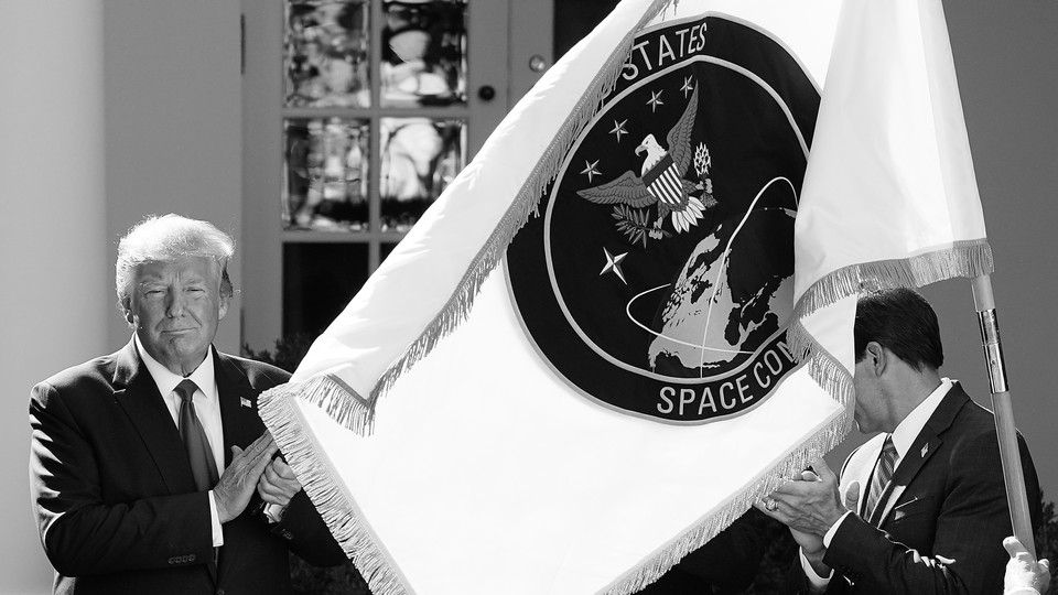 Former President Donald Trump poses with the flag of the U.S. Space Command