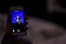 An audience member takes a video of President Donald Trump on her phone.
