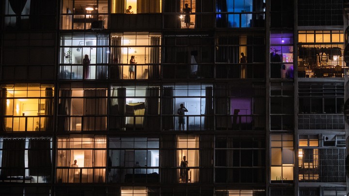People in windows viewed through balconies