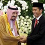 Saudi King Salman shakes hands with Indonesian President Joko Widodo.