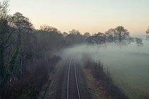 A photo of train tracks shrouded in fog